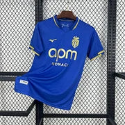 Maillot AS Monaco Extérieur 2025/2026, face avant sur fond grillagé