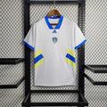 Maillot Leeds United Domicile 2024/2025 sur fond grillagé