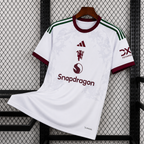 Maillot Manchester United Extérieur 2026/2027 sur fond grillagé
