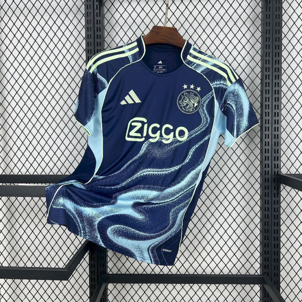 Maillot Ajax Extérieur 2025/2026 sur fond grillagé