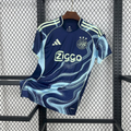 Maillot Ajax Extérieur 2025/2026 sur fond grillagé